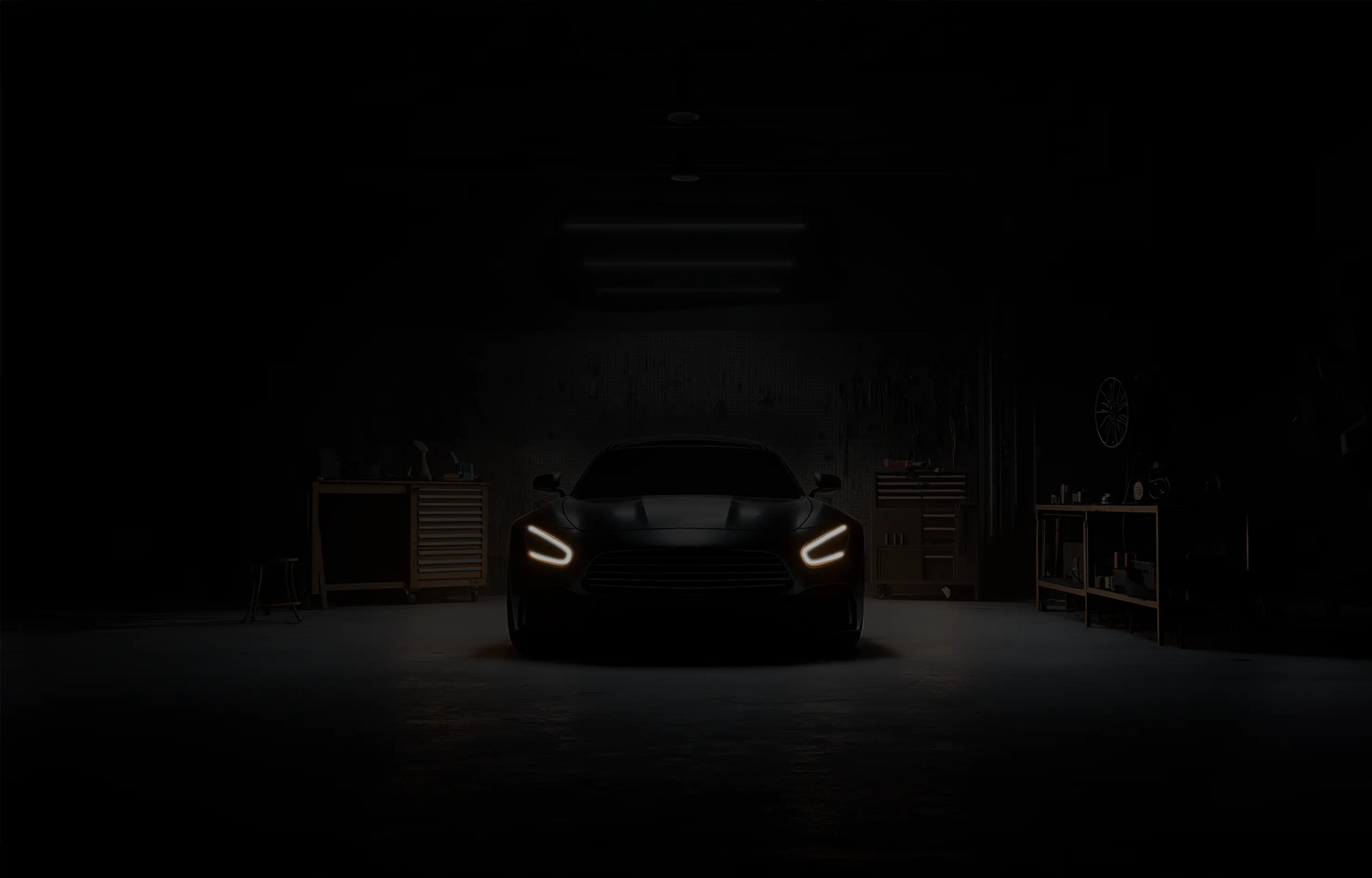 Dark automotive facility with car headlights only